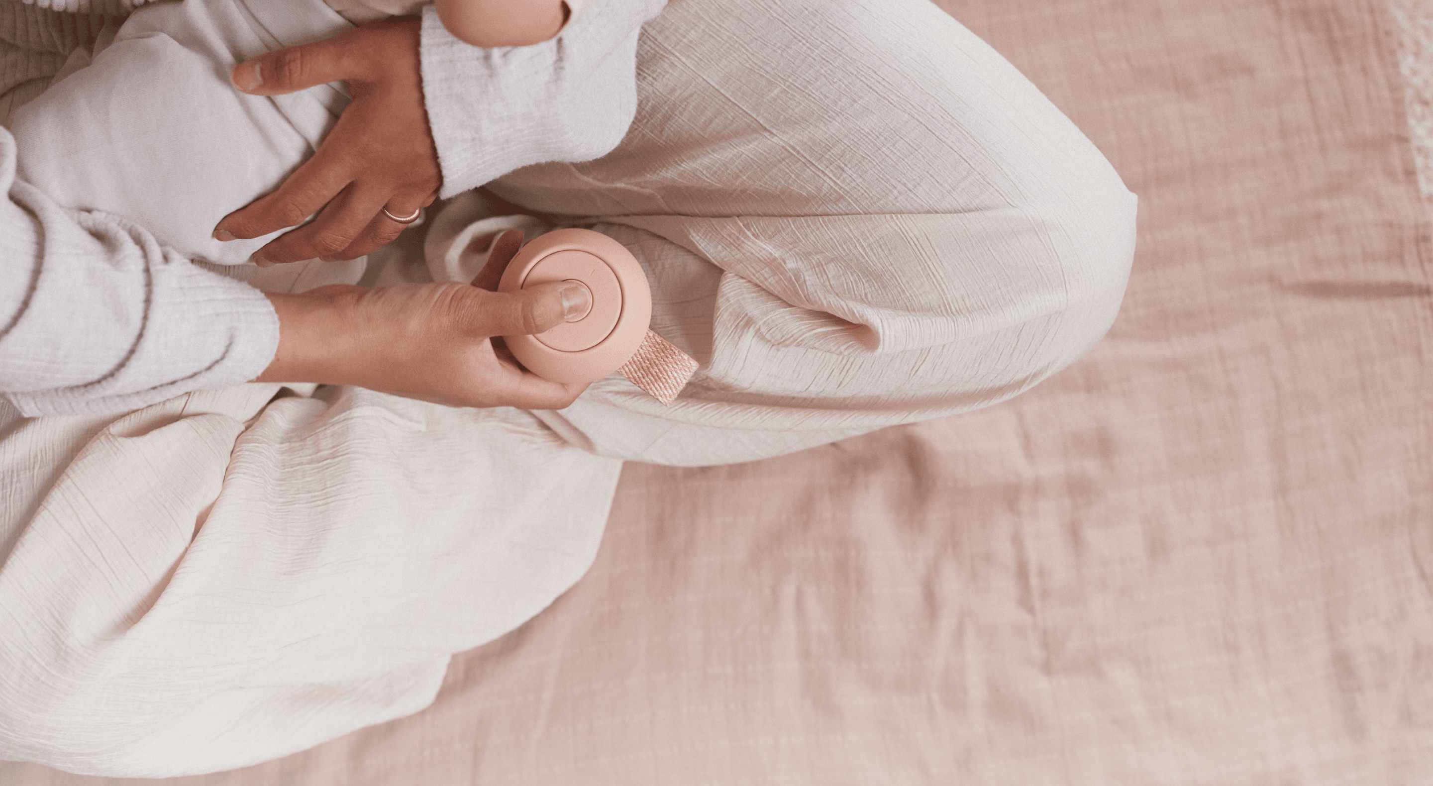 Mother holding baby while pressing button on Hatch peach rest go