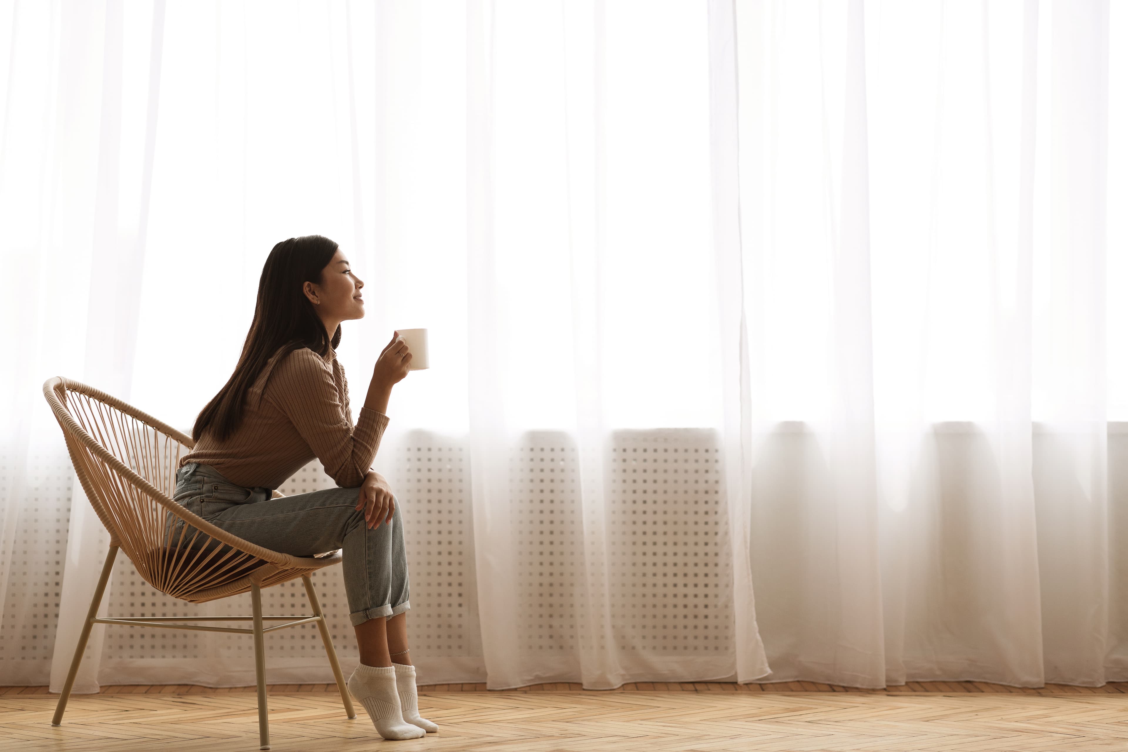 Woman sitting in a chair enjoying a morning beverage
