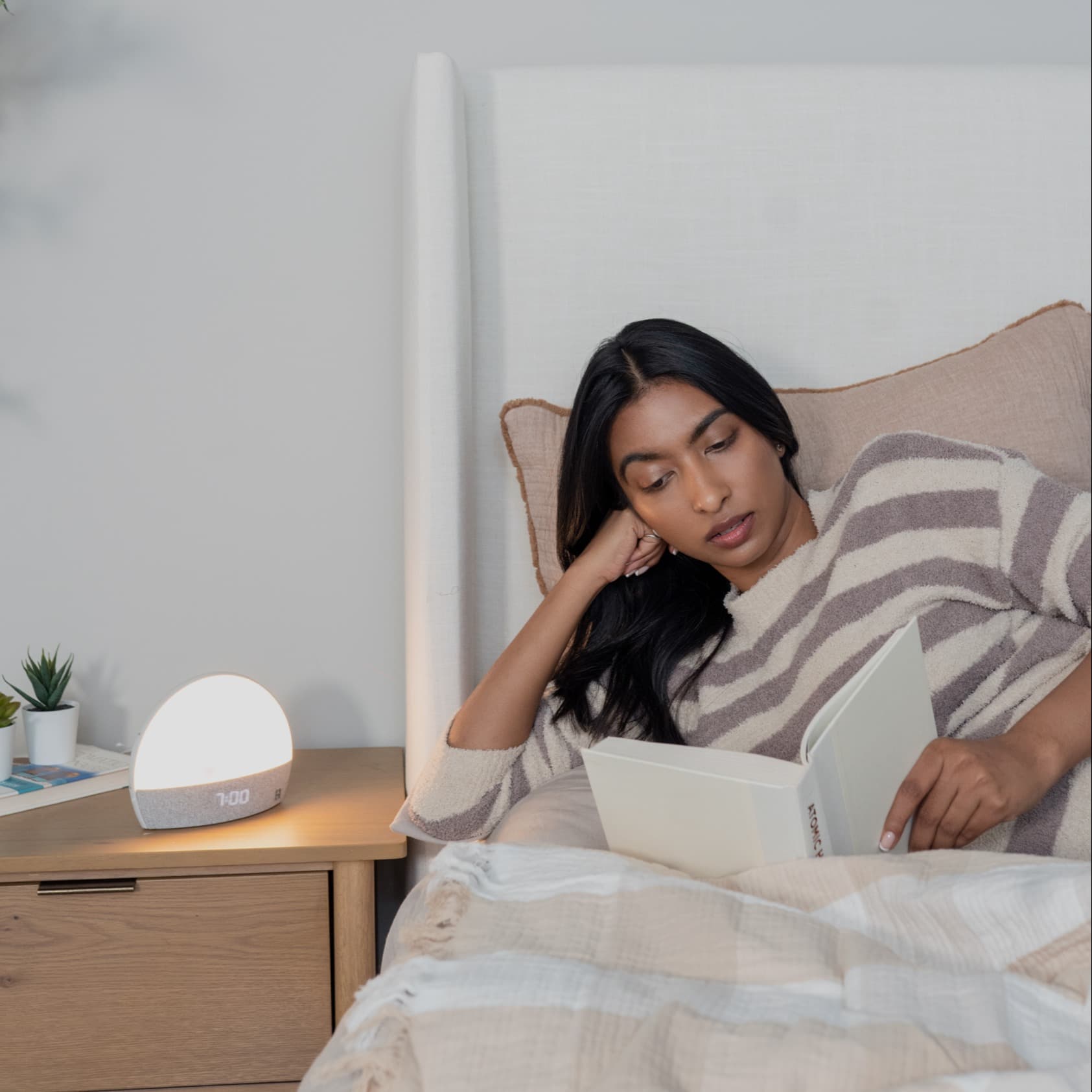 Woman in bed reading a book