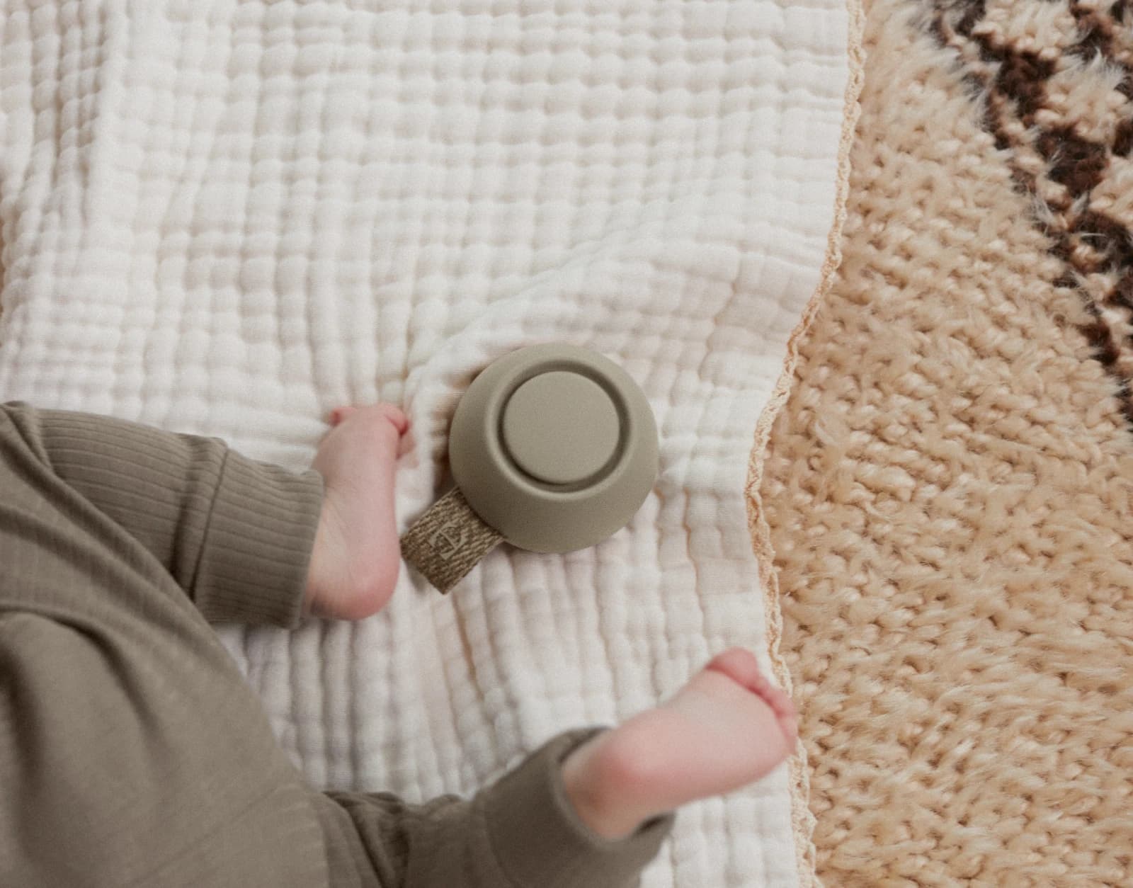 Hatch Go Greige laying next to a crawling baby