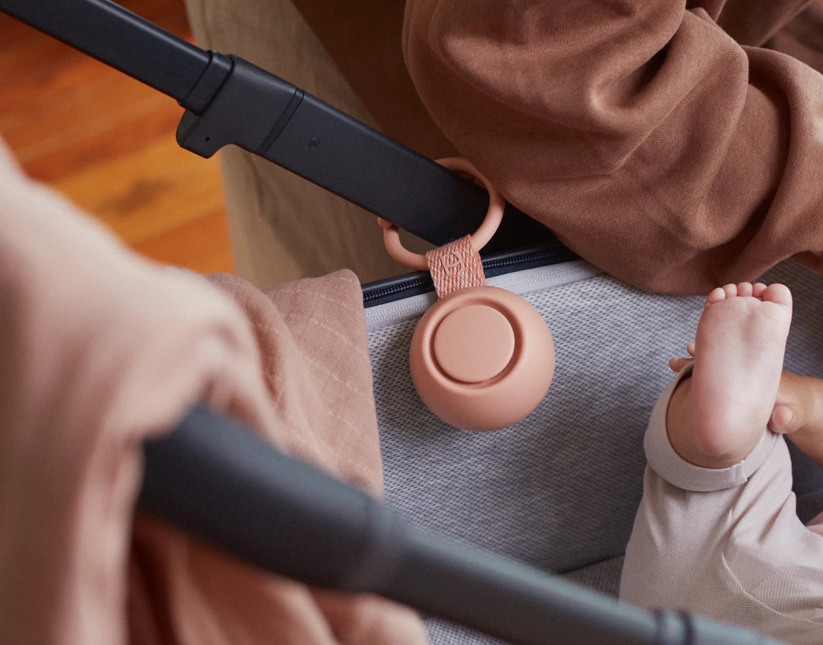 Hatch Go Peach clipped to a stroller while a mother attends her baby in it