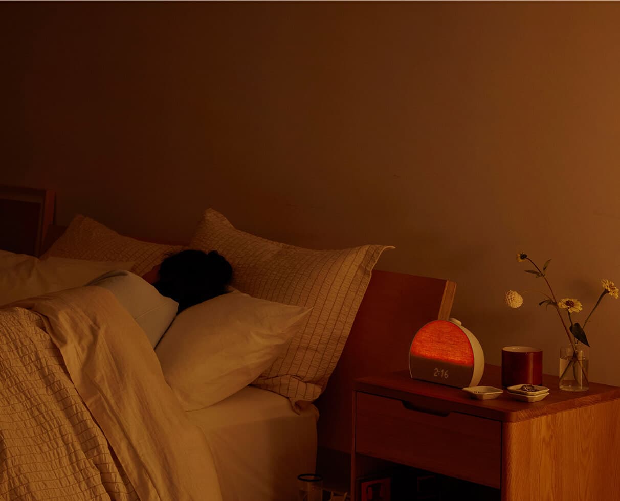 Person sleeping in bed with Hatch Restore red light