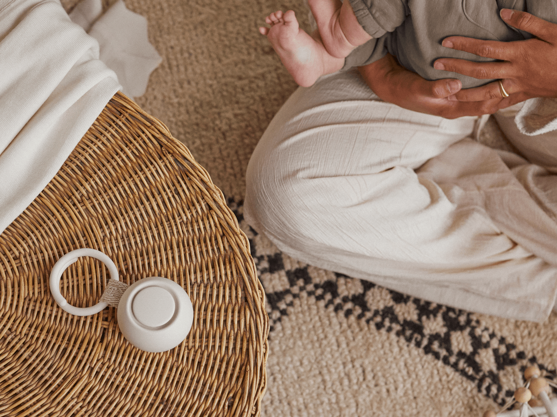 Hatch Go putty colorway on a side table next to a mother carrying her baby